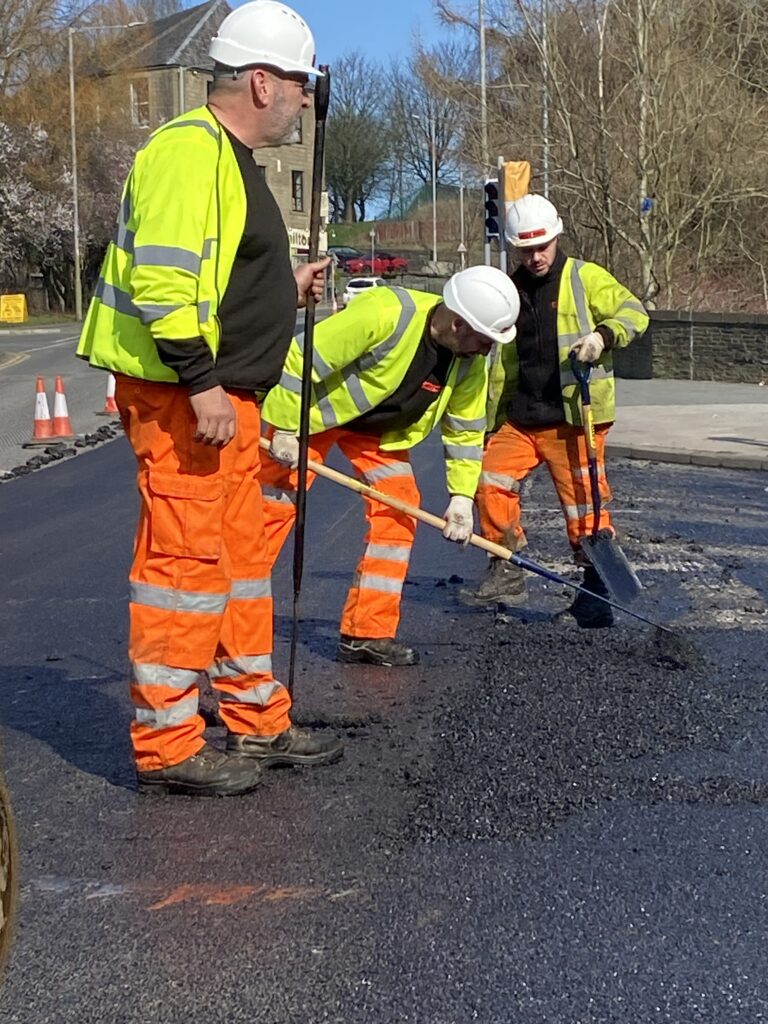 Tar.co.uk is for sale. Workmen raking tarmac on a road